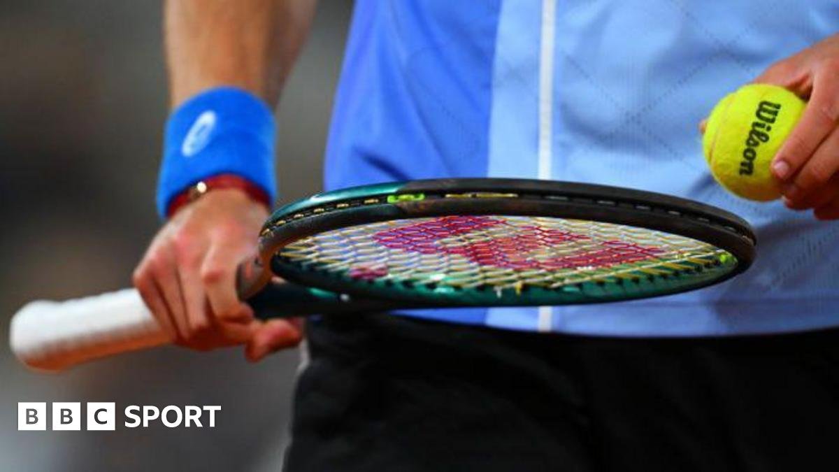 Close up of a player with a tennis racket holding a tennis ball