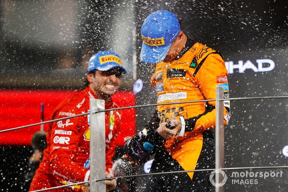 Carlos Sainz, Scuderia Ferrari, 2nd position, Lando Norris, McLaren F1 Team, 1st position, celebrate on the podium with Champagne