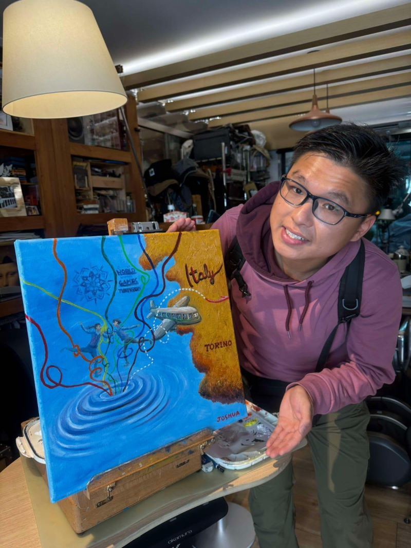 A young man showing off a painting he did.